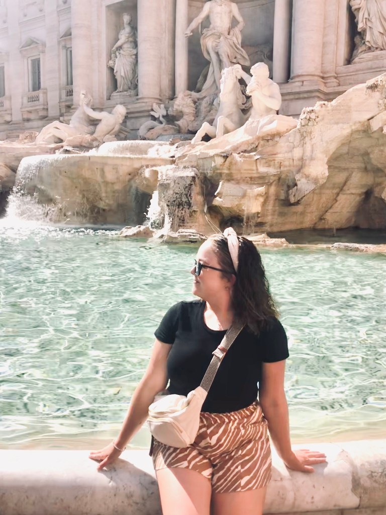 Girl looking back at Trevi Fountain in Rome, Italy