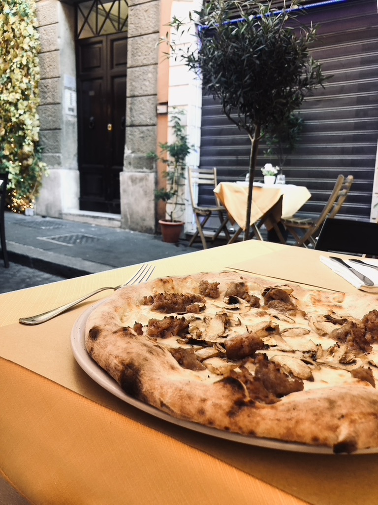 Italian pizza with cheese and sausage at a street restaurant in Rome, Italy