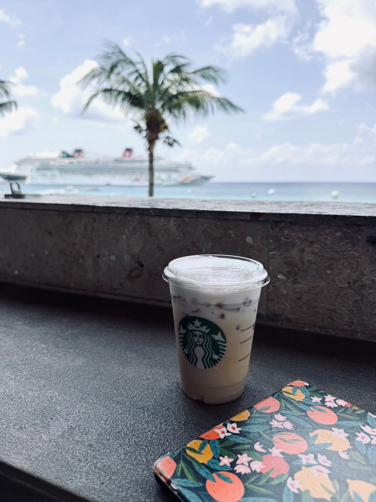 View of ocean with starbucks coffee and kindle on table at Starbucks in Cozumel, Mexico