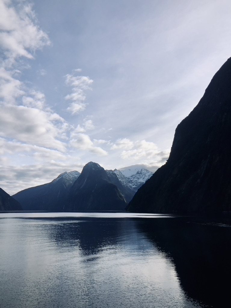 Shadow of mountains and water reflection at Milford Sound, New Zealand