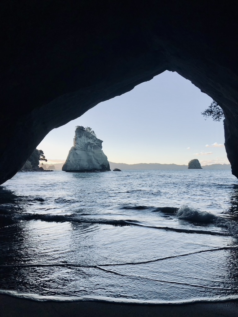 Natural arch and beach at Cathedral Cove in New Zealand during golden hour