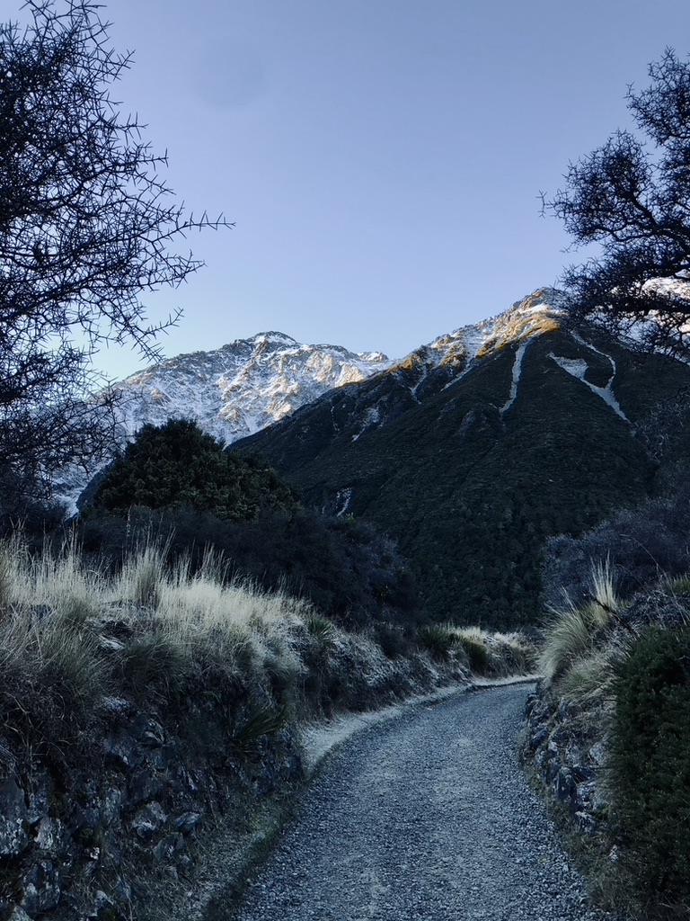 Trail path with snow capped mountains on the Hooker Valley Track, New Zealand