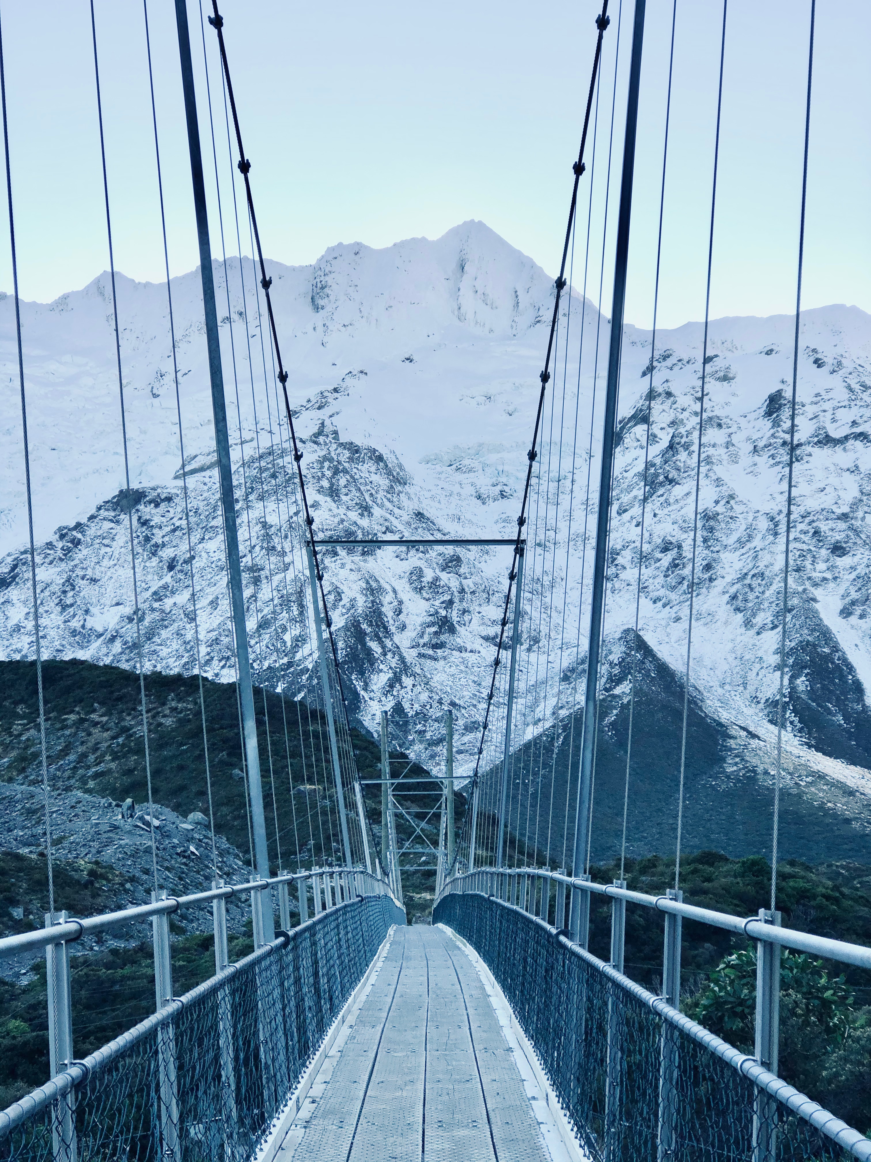 Suspension bridge with snowy mountains on the Hooker Valley Track, New Zealand