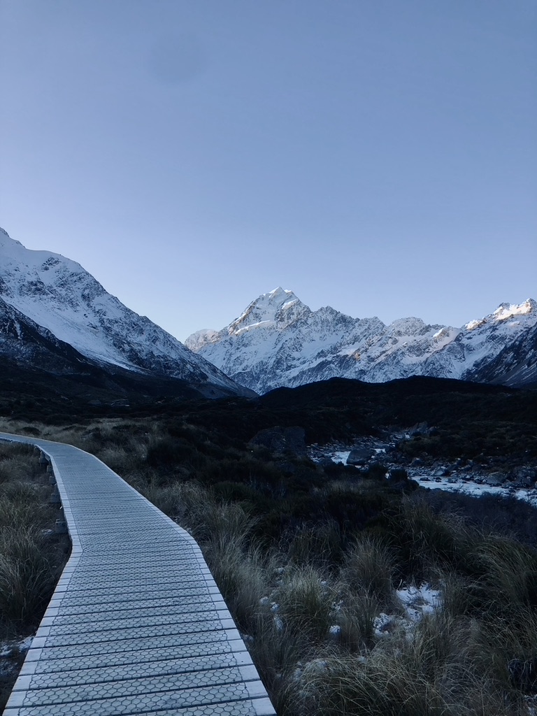 Wooden path on the trail with Mt Cook in the background at Hooker Valley Track, New Zealand