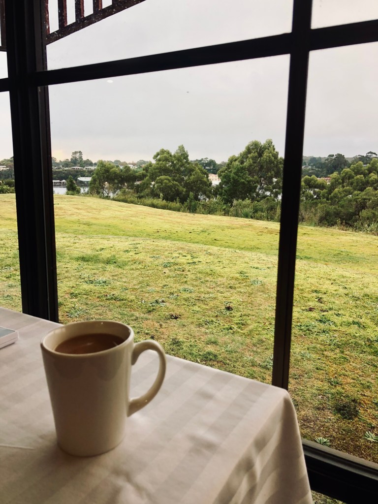 Coffee cup and window at a hotel with a view of Strahan, Tasmania