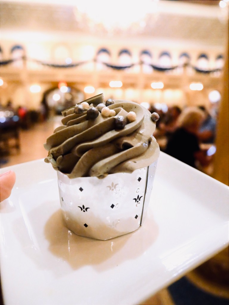 Hand holding "grey stuff" cupcake at be our guest restaurant at Magic Kingdom, Walt Disney World
