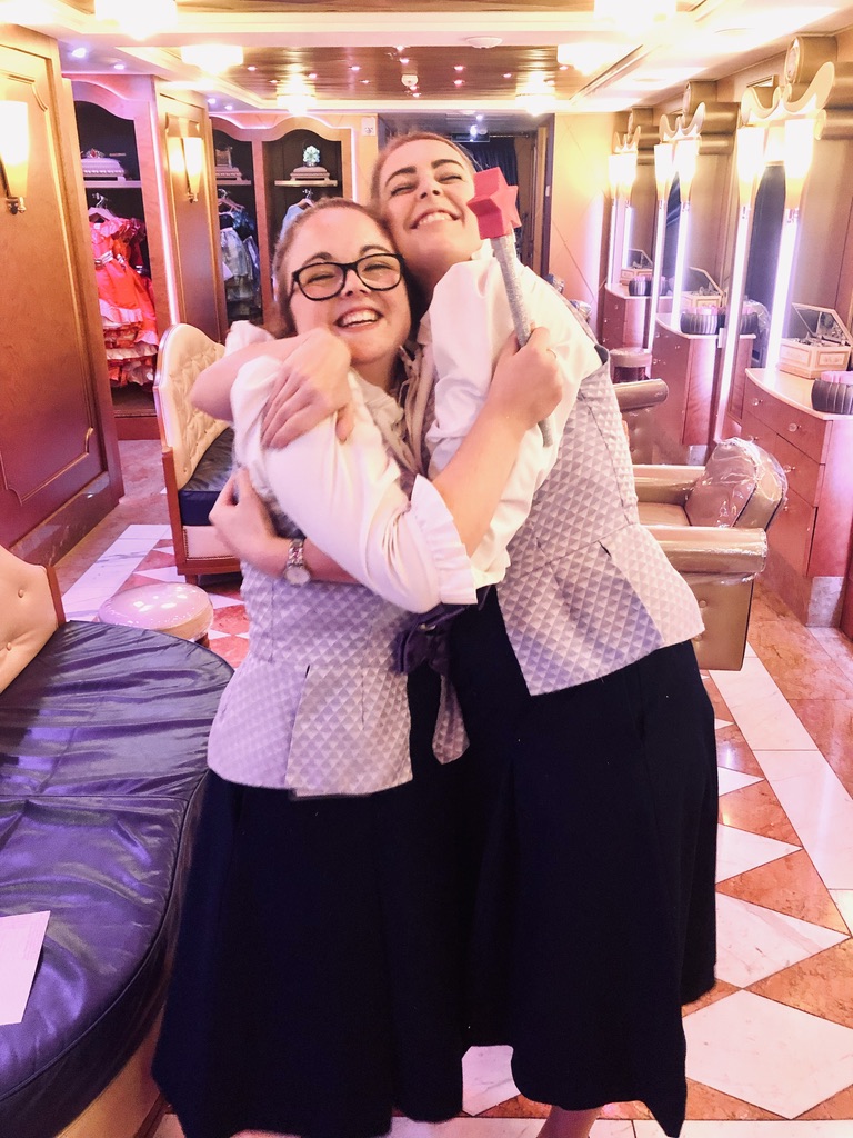 Disney Cruise Line Crew Members in Bibbidi Bobbidi Boutique outfits hugging in Boutique