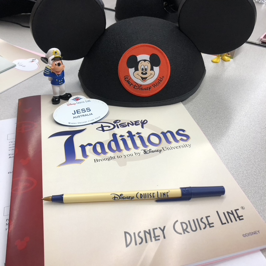 Disney Crew Member traditions book with mickey mouse ears and name tag