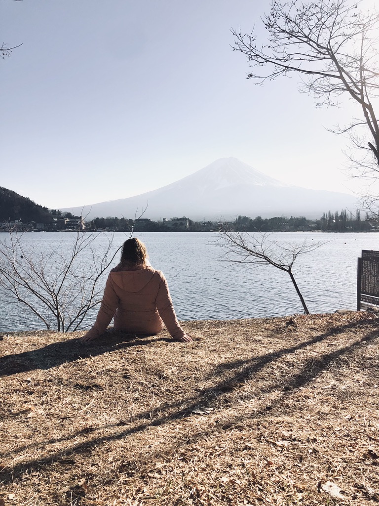 Girl sitting looking at view of Mt Fuji from kawaguchiko, Japan