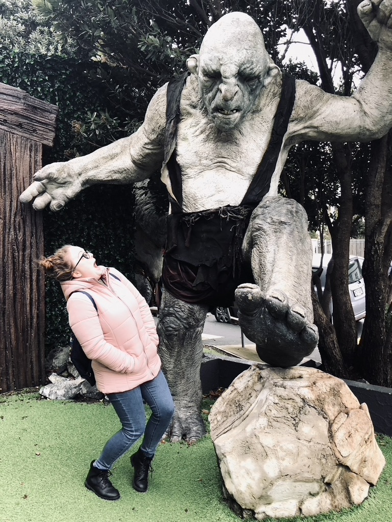Girl pretending to be scared of troll at weta workshop in Wellington, New Zealand