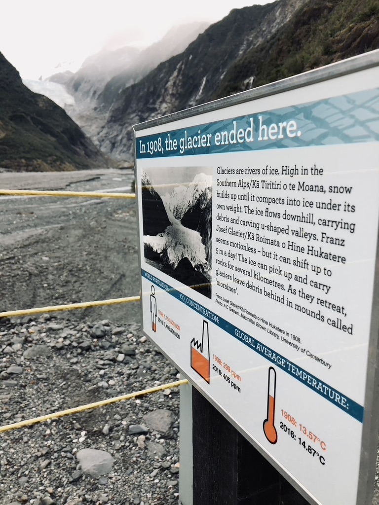 Sign explaining where the glacier ended in 1908 compared to today where glacier is far in the distance in New Zealand