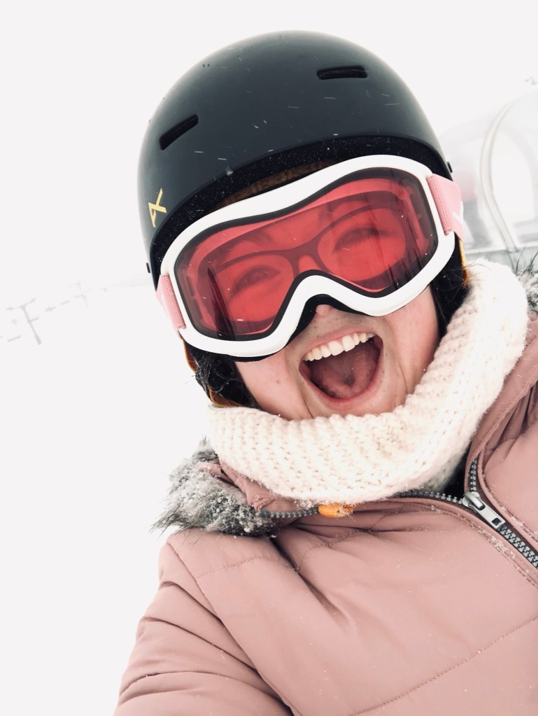 Girl in pink jacket and pink ski goggles taking selfie in Queenstown, New Zealand