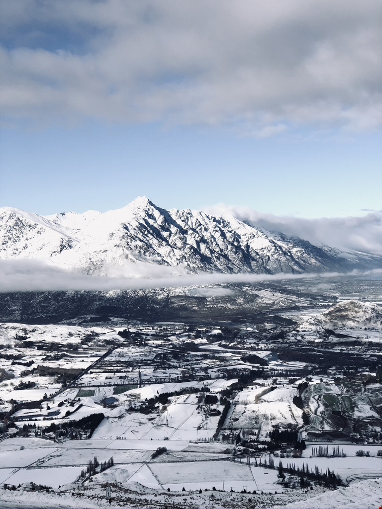 View of snow covered mountains and town from Mt Coronet in Queenstown, New Zealand