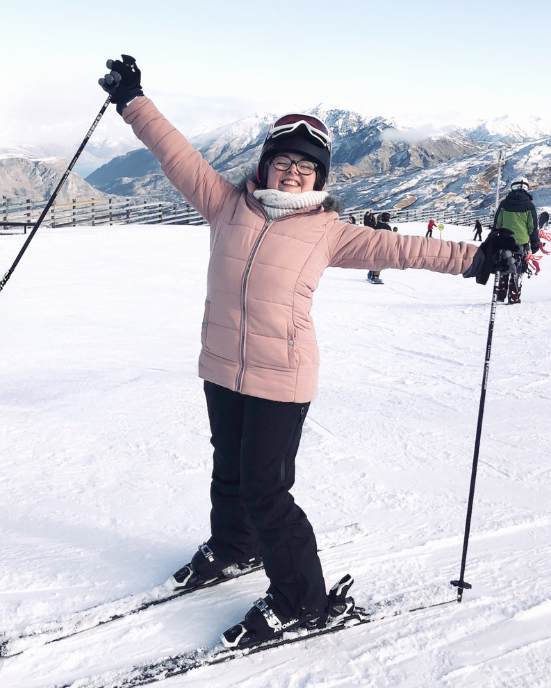 Girl in pink jacket in ski gear on the slopes at Coronet Peak in Queenstown, New Zealand