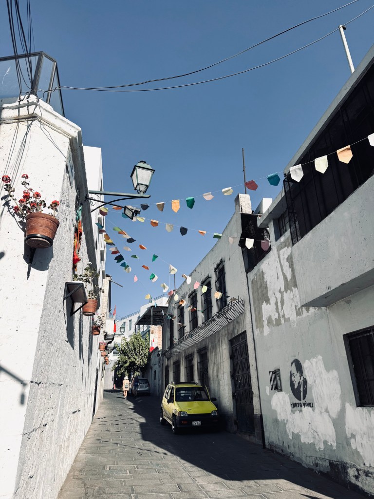 Cute street with bunting and old white wash building in Arequipa, Peru