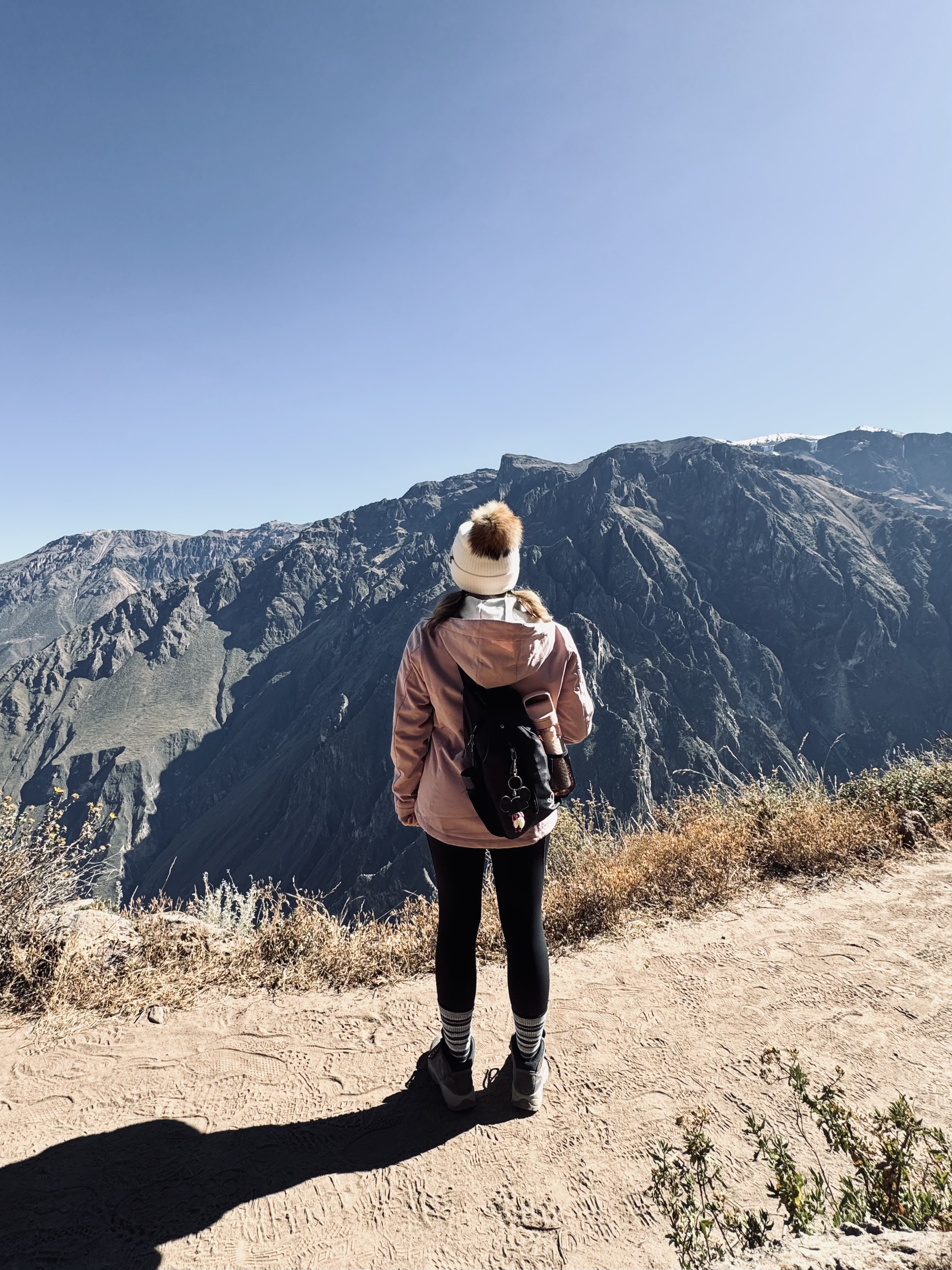 Girl in pink coat looking out at Colca Canyon, Peru