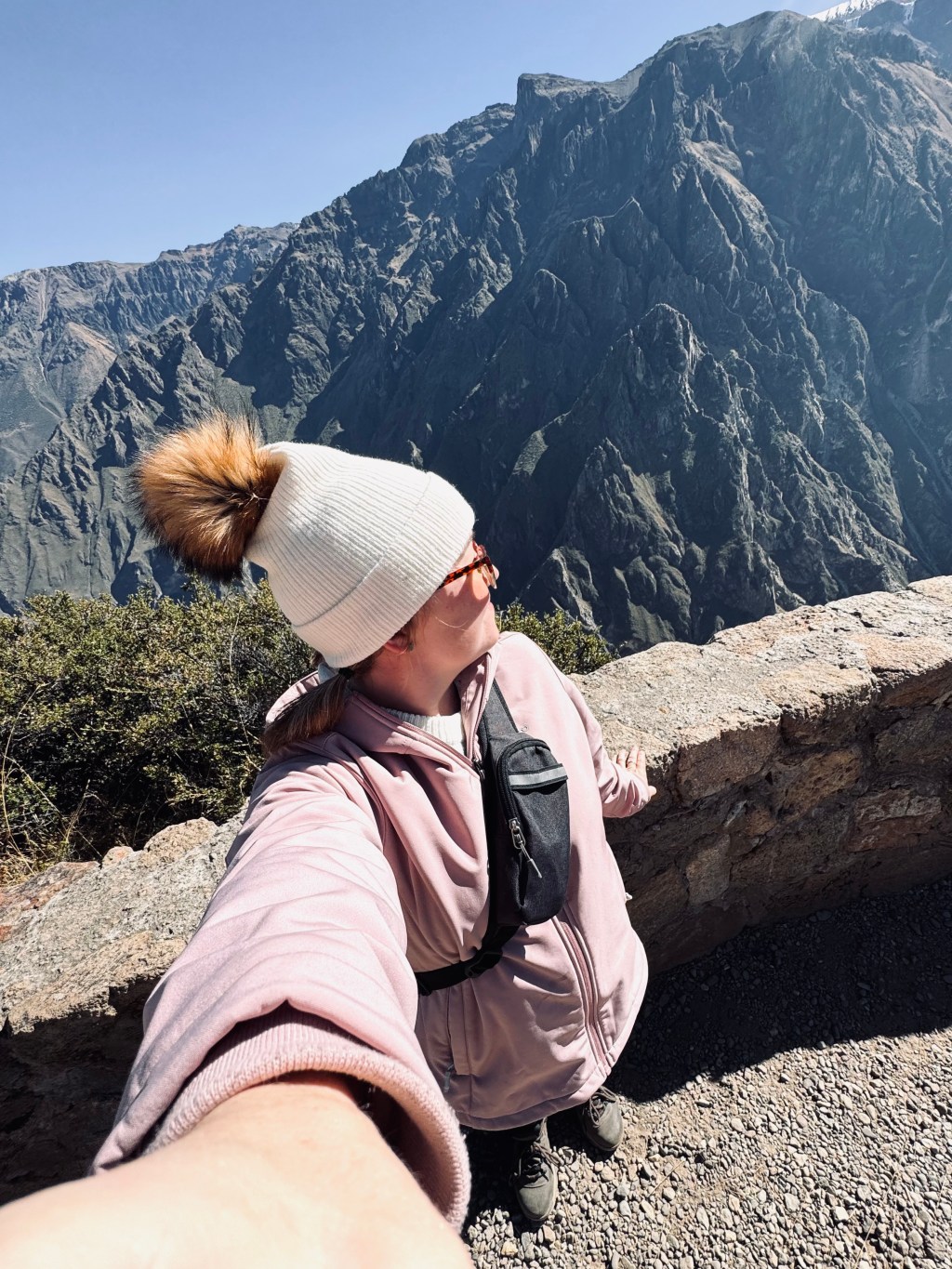 Girl in pink jacket taking selfie in Colca Canyon, Peru