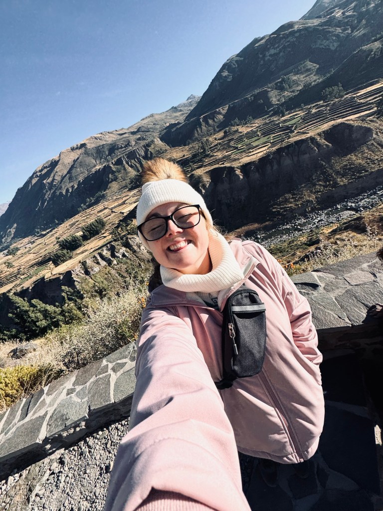Girl in pink coat taking selfie at Colca Canyon, Peru
