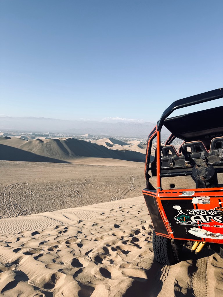 Dune buggy with sand dunes in the background in Huacachina, Peru
