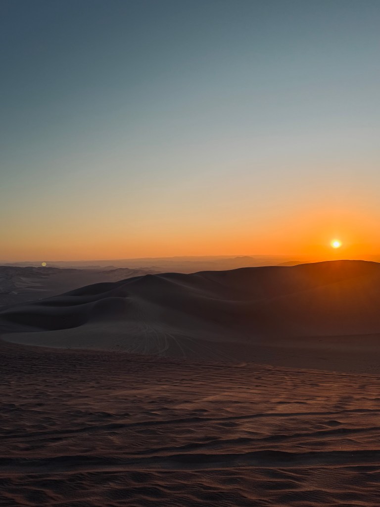 Sunset over sand dunes in Huacachina, Peru