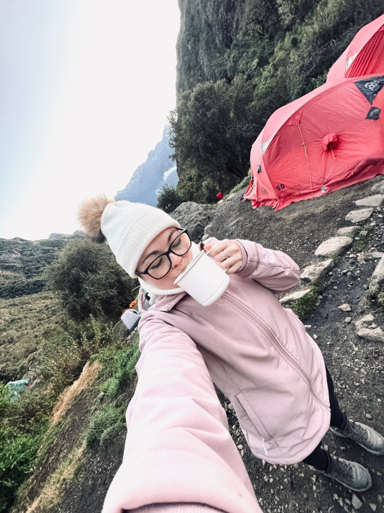 Girl sipping coca tea at camp on the Inca Trail in Peru