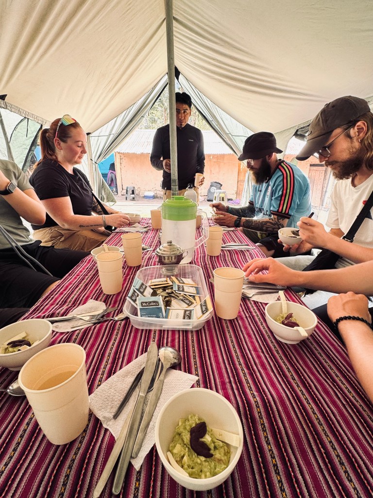 Trekking group inside tent eating lunch on the Inca Trail, Peru