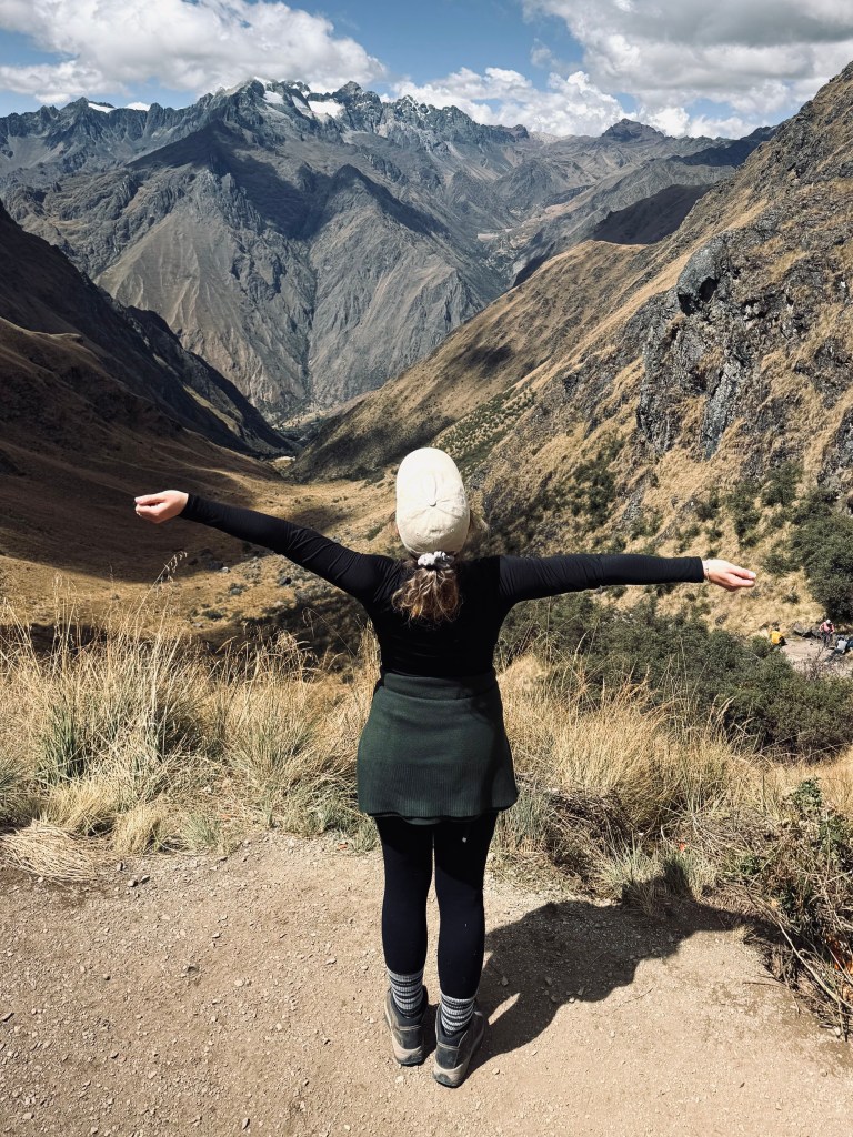 Girl looking out at mountains from the top of Dead Womans Pass on the Inca Trail in Peru