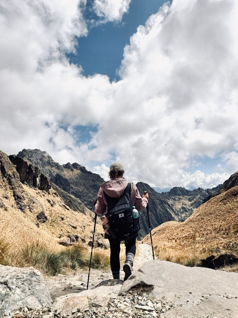 Girl with hiking poles and backpack hiking the Inca Trail in Peru