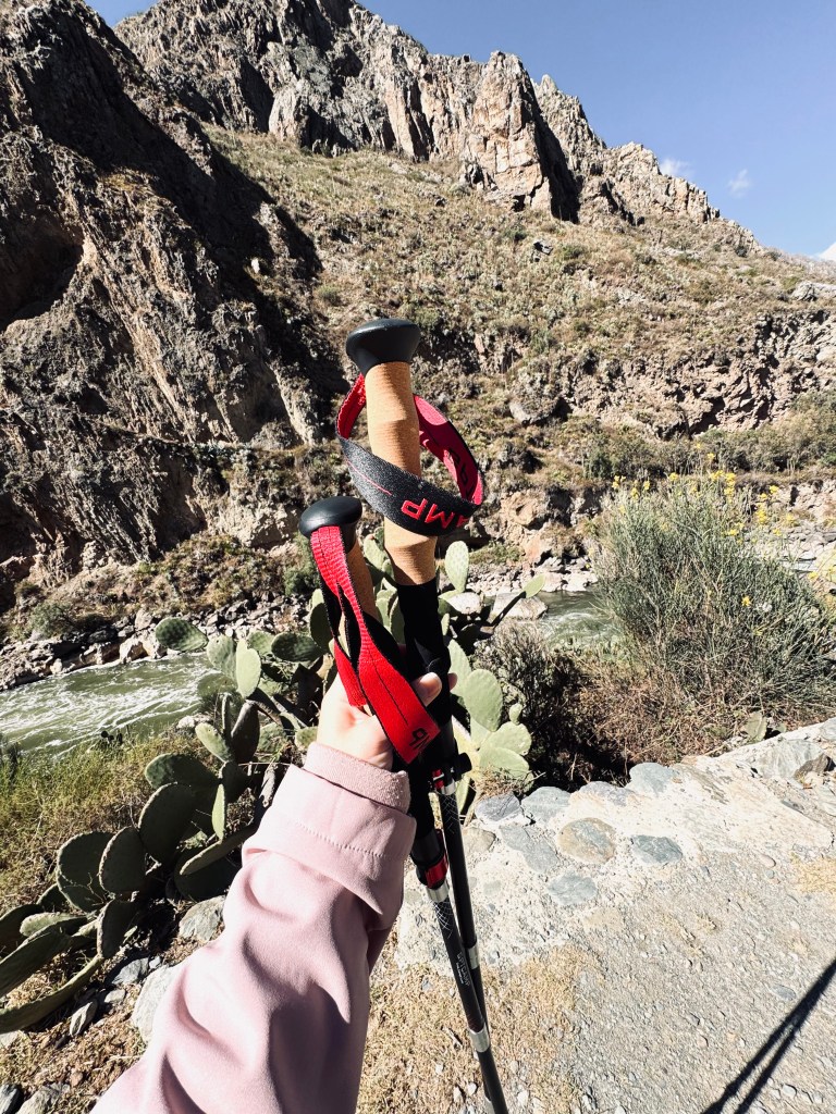 Hand holding hiking poles at the entrance to the Inca Trail, Peru