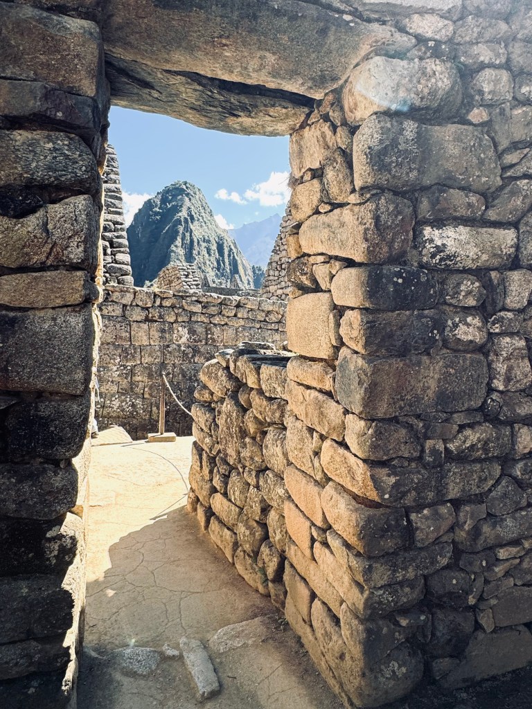 Machu Picchu ruins door frame with mountains in distance on the Inca Trail in Peru