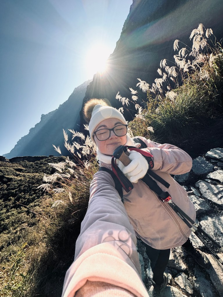 Girl holding hiking poles at sunrise on the Inca Trail in Peru