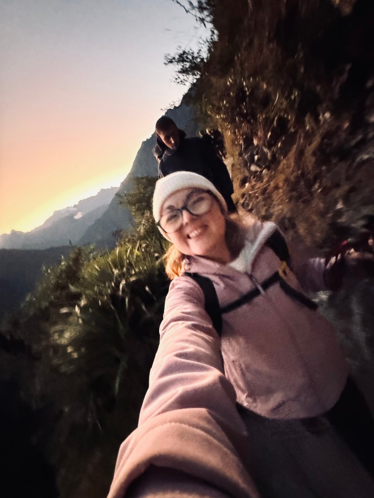 Girl taking selfie at sunrise on the last day of the Inca Trail in Peru
