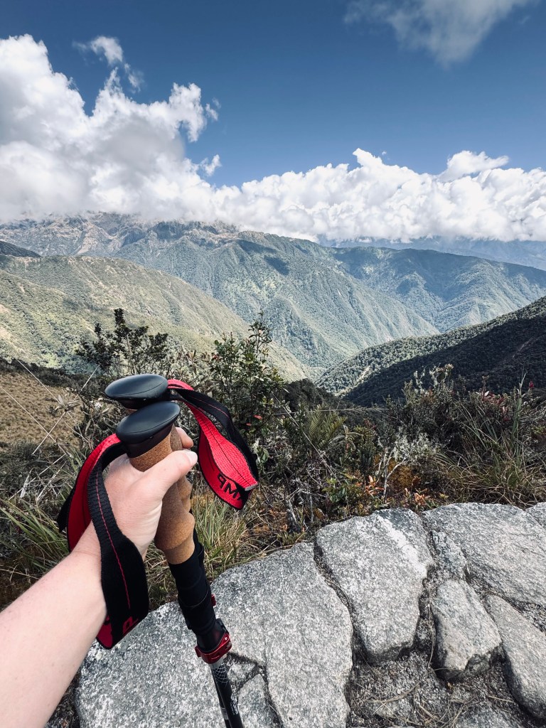 Hand holding trekking poles on the Inca Trail in Peru