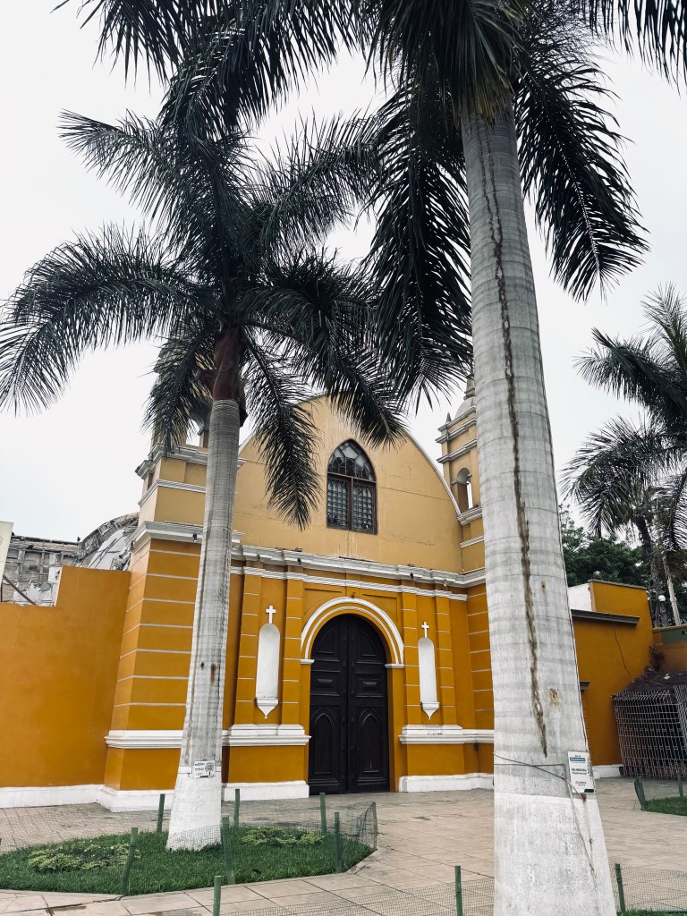 Yellow church with palm trees in Barranco, Lima, Peru