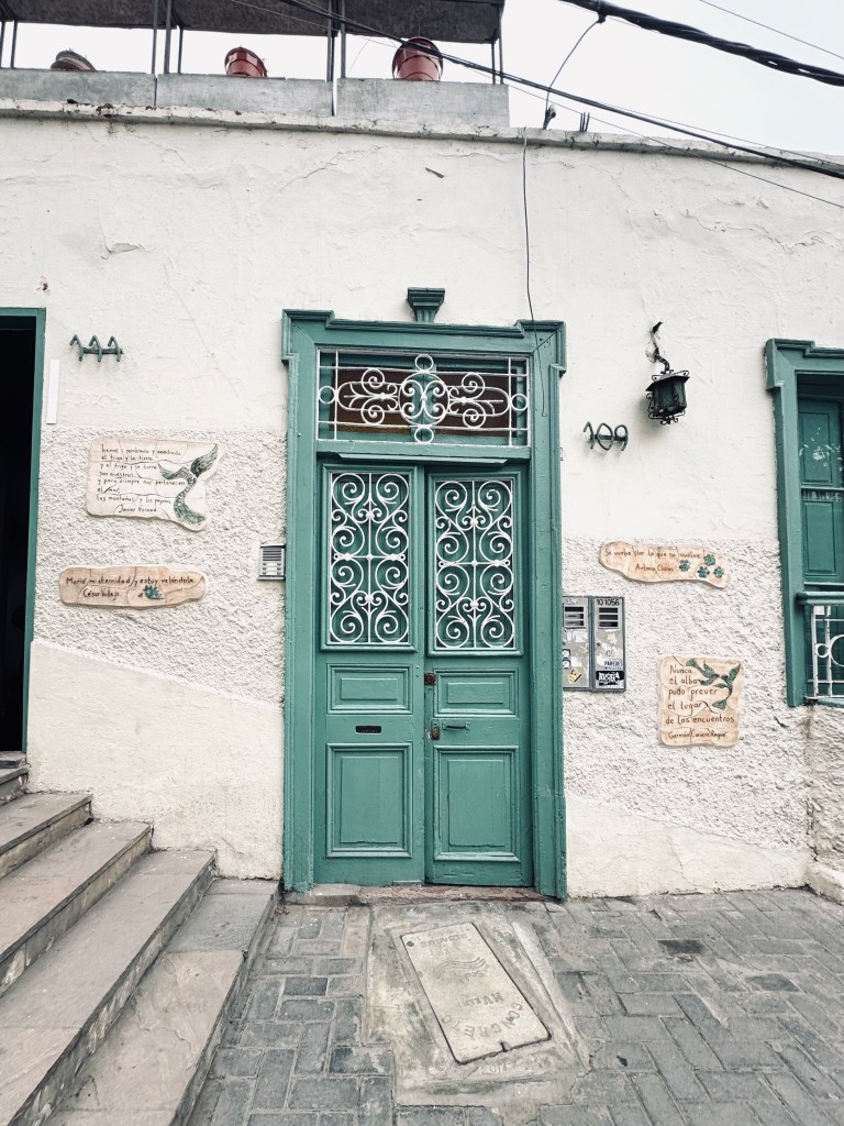 Cute teal door with concrete wall and floor in Barranco, Lima, Peru