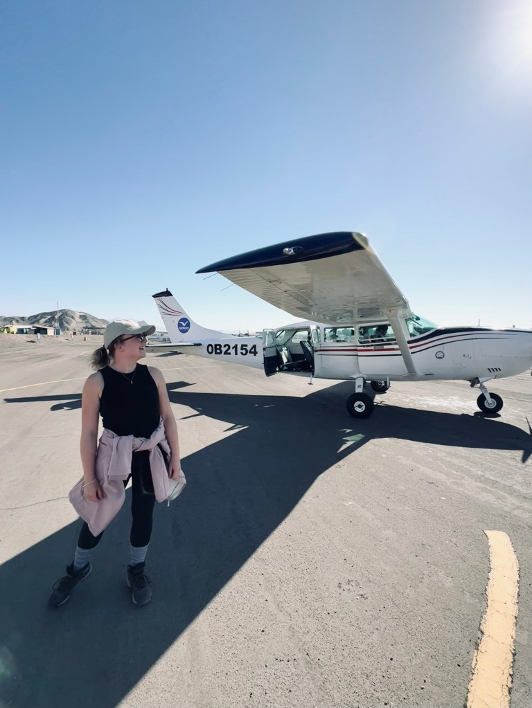 Girl standing in front of small plane ready for Nazca Lines flight tour in Nazca, Peru
