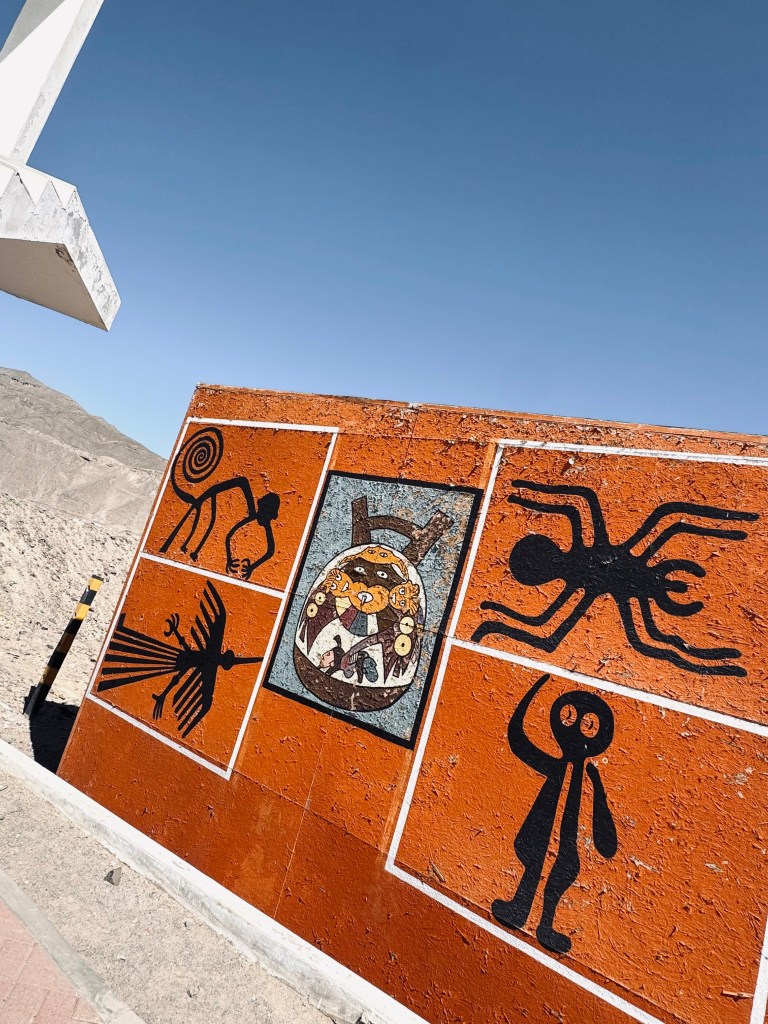 Nazca Lines mural on orange wall with blue sky in background in Nazca, Peru