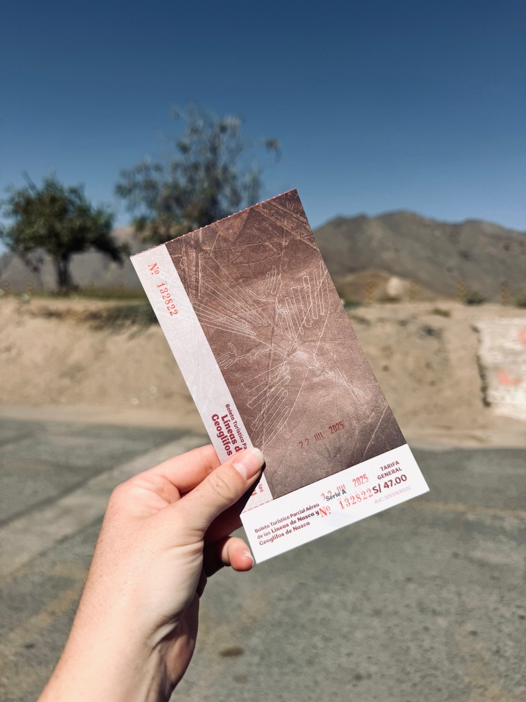 Hand holding Nazca Lines flight tour ticket in Nazca, Peru