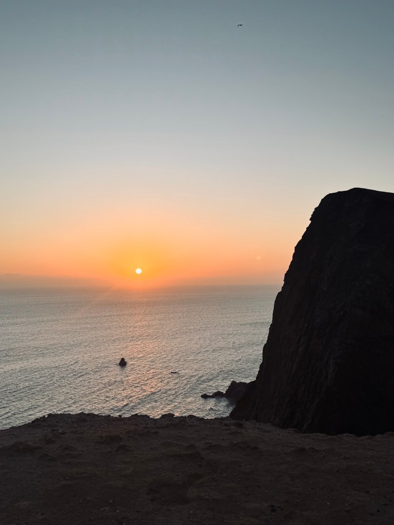 Sunset over ocean and cliffs at Paracas National Reserve, Peru