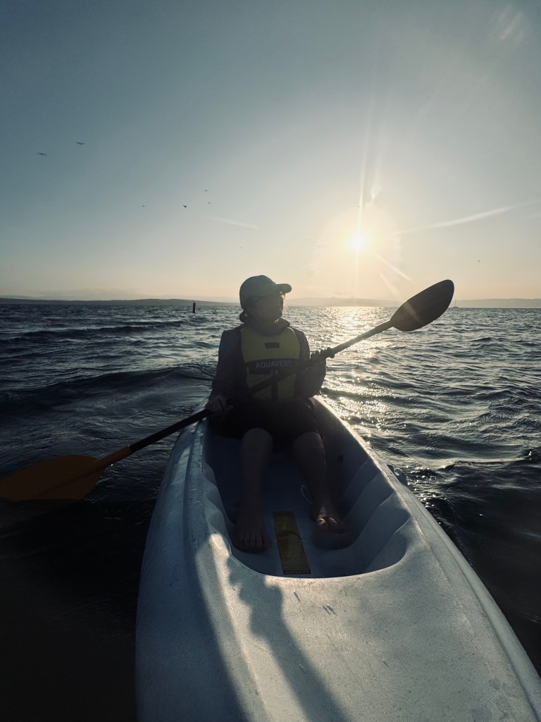 Girl kayaking at sunset in the ocean in Paracas, Peru