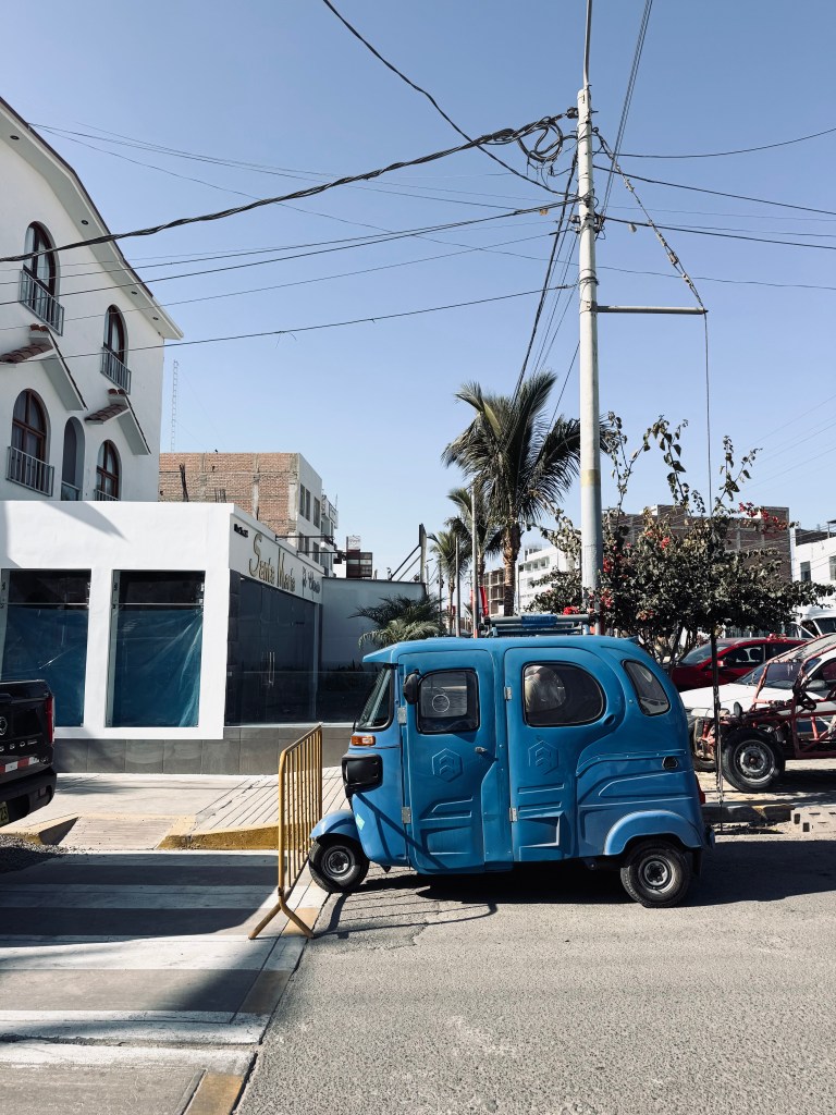 Blue tuk tuk parked on the street in Paracas, Peru
