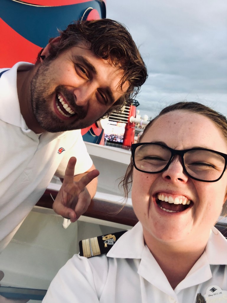 Two crew members taking a selfie laughing onboard a disney cruise ship