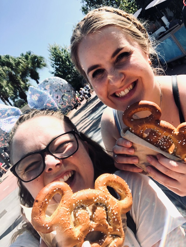 Two friends taking a selfie with mickey pretzels at walt disney world