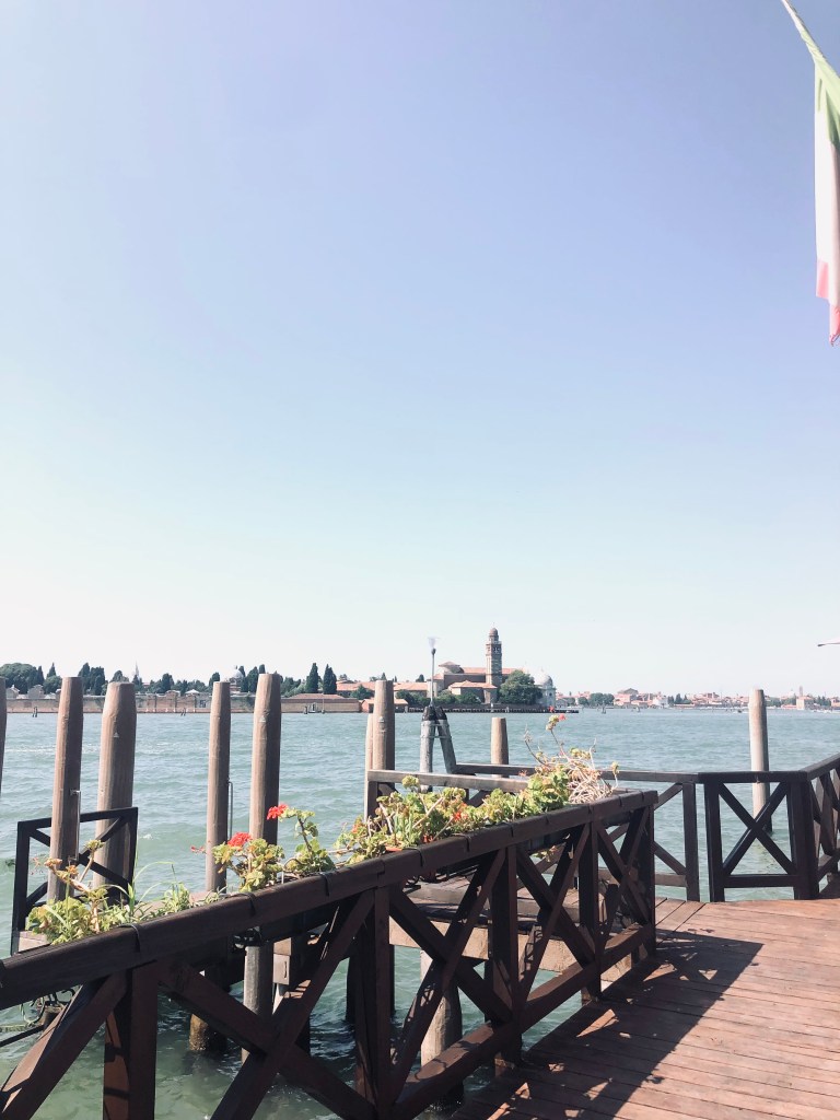 Blue water over a pier on Murano island in Venice, Italy