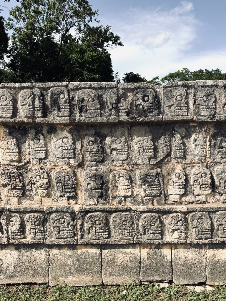 Ancient skull carvings on rock wall in Chichen Itza, Mexico