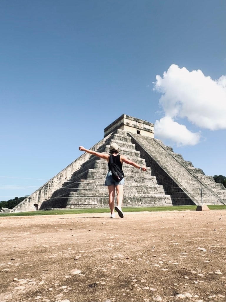 Girl walking towards pyramid at Chichen Itza, Mexico