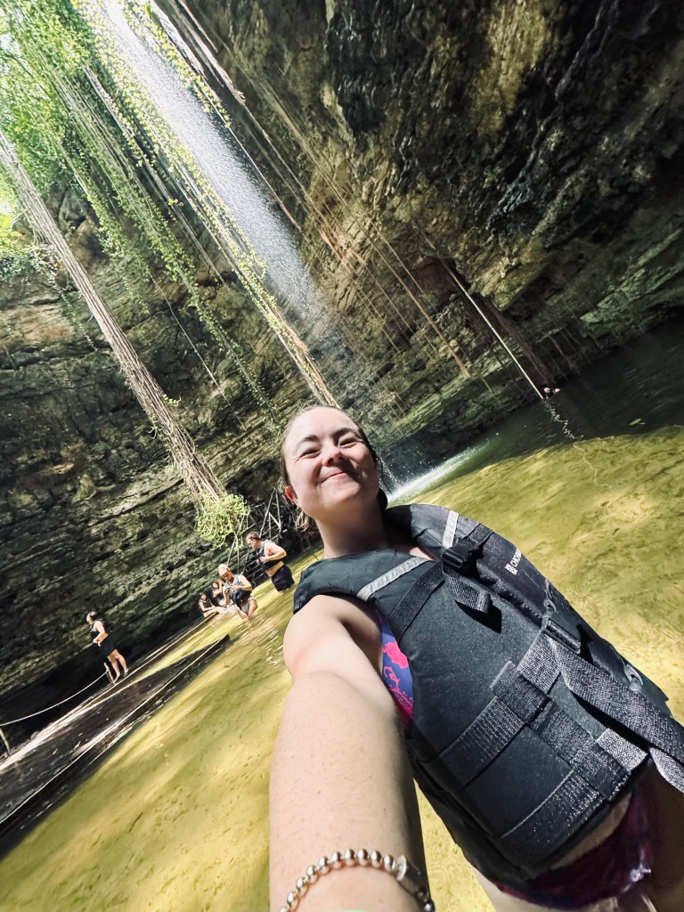 Girl taking selfie in a life jacket at Chichikan Cenote sinkhole in Mexico
