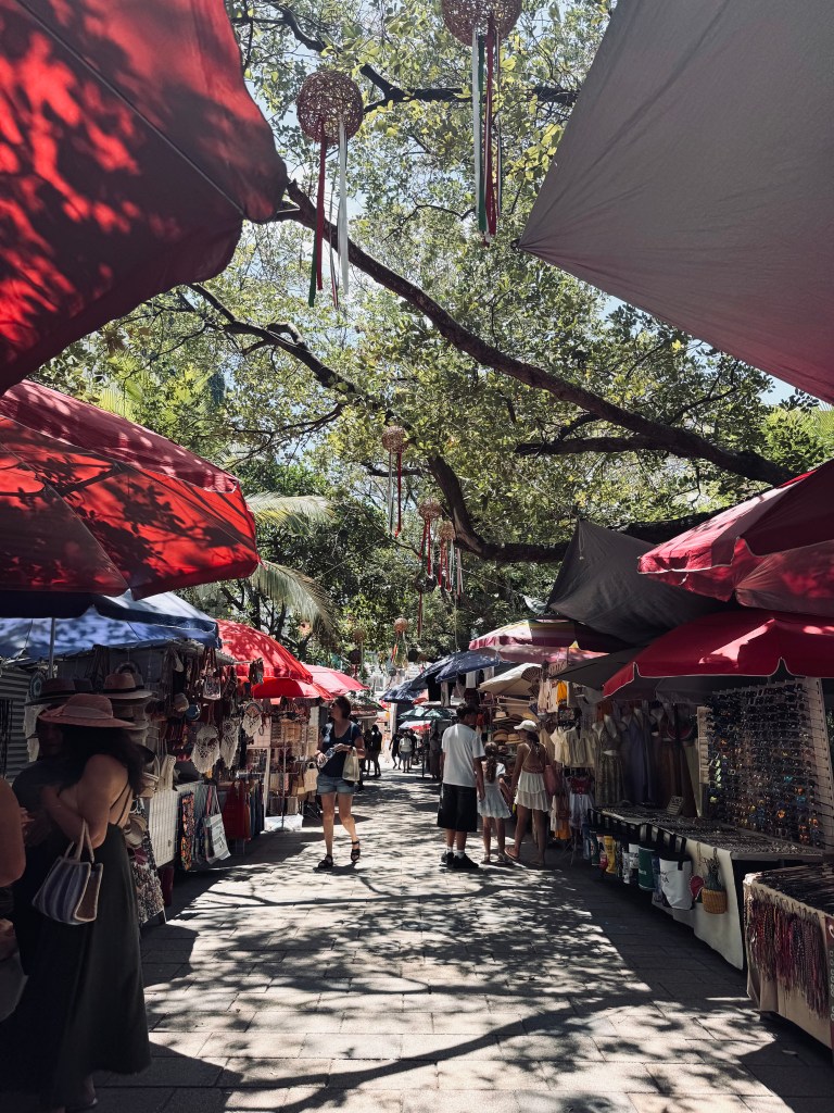 Street full of market stalls and shady trees along Quinta Avenida at Playa del Carmen in Mexico