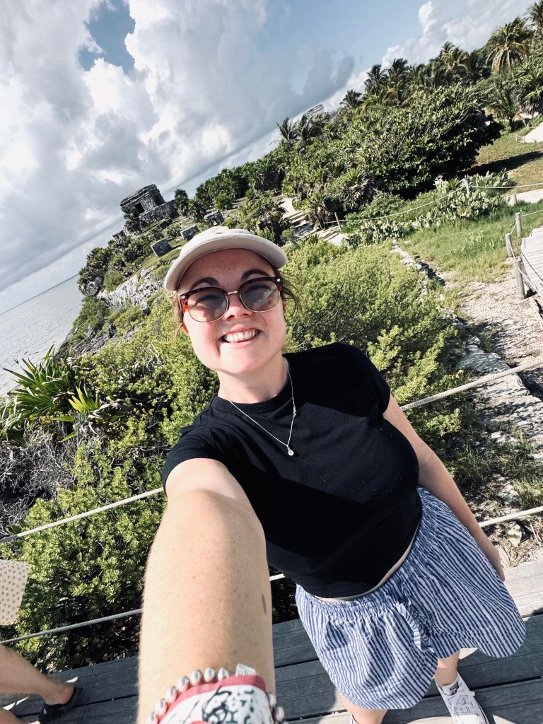 Girl taking selfie with ruins and beach at Tulum Ruins, Mexico