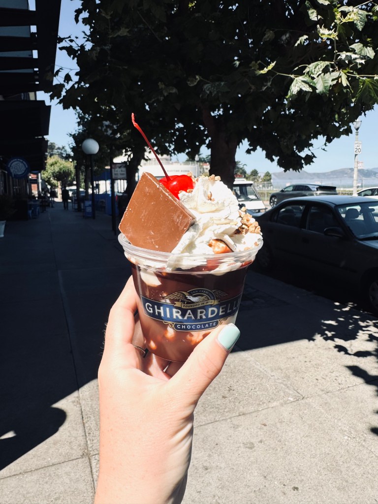 Hand holding Ghirardelli ice cream sundae in San Fransisco, USA